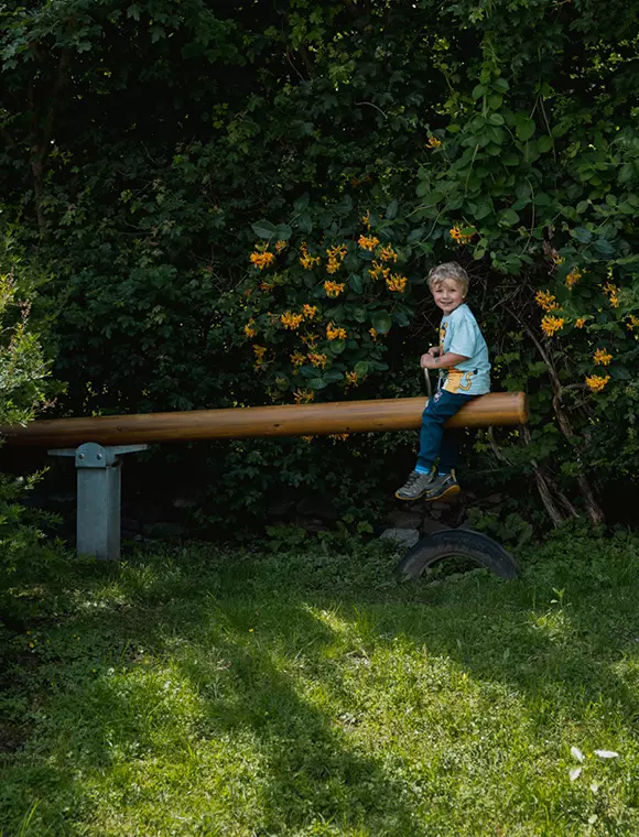 Kind auf einer Wippschaukel im Garten