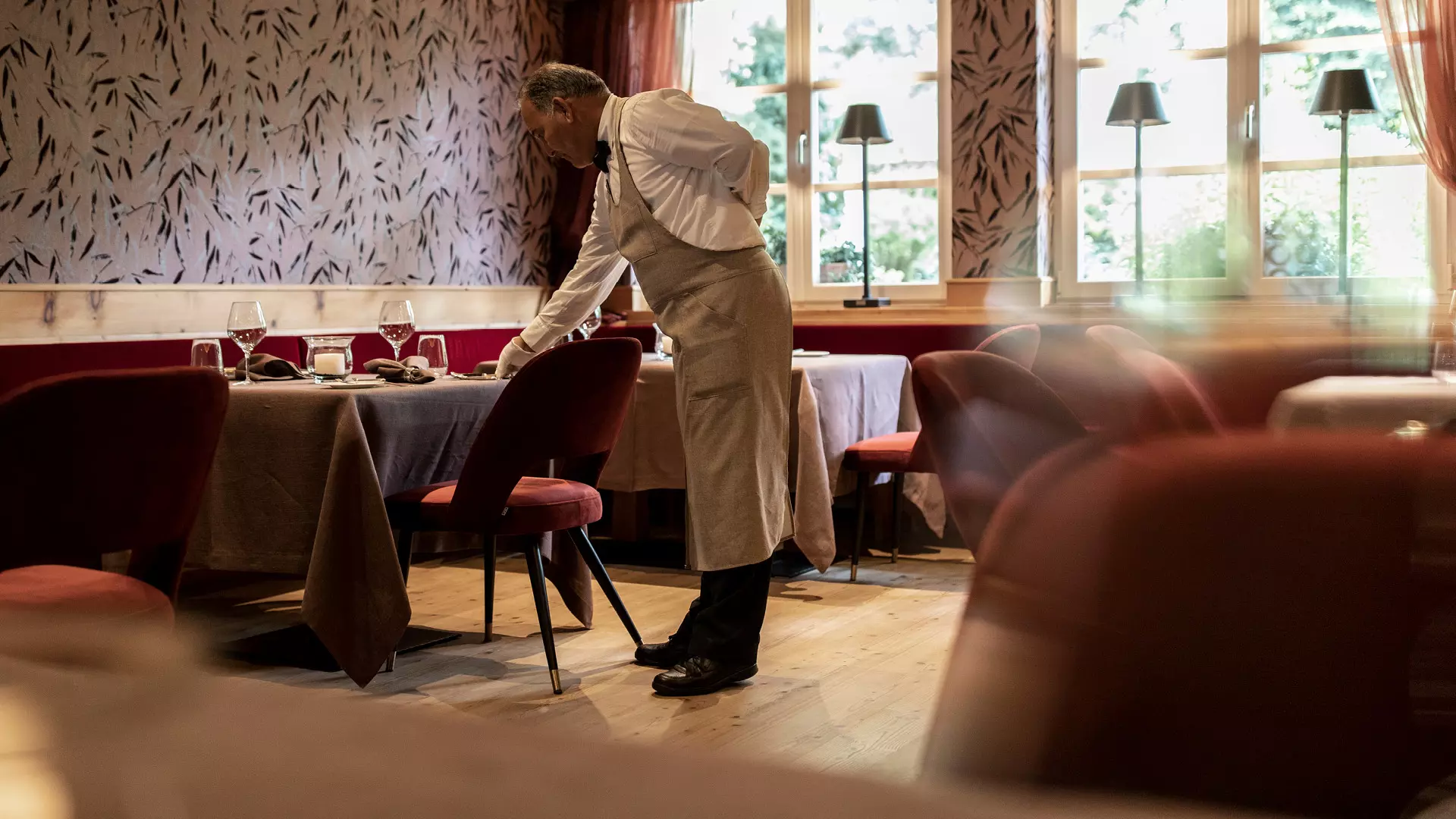 Angestellter deckt einen Tisch im Restaurant des Giardino Marling
