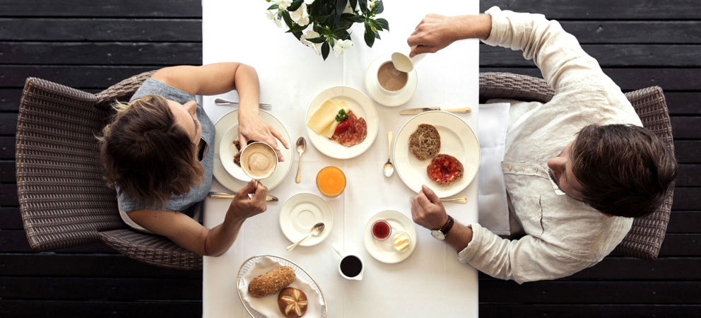 Aufnahme von Oben eines Paares beim Frühstück am Tisch des Giardino Marling