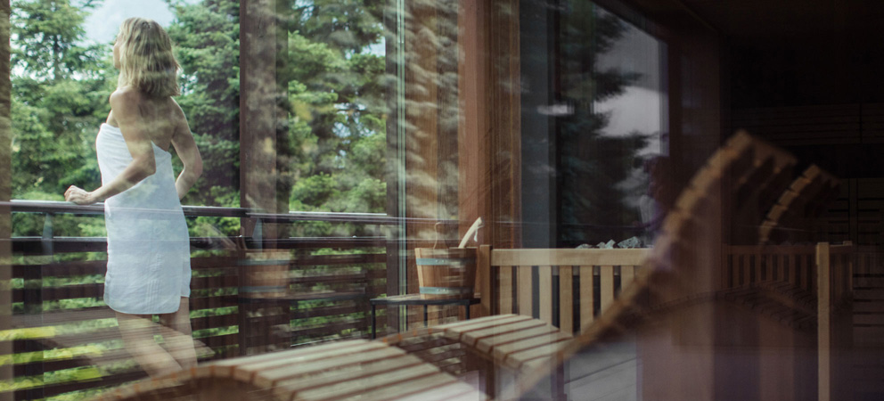 Reflex auf einer Glastür der Spa des Giardino Marling, im Hintergrund sieht man eine Dame in Bademantel auf dem Balkon