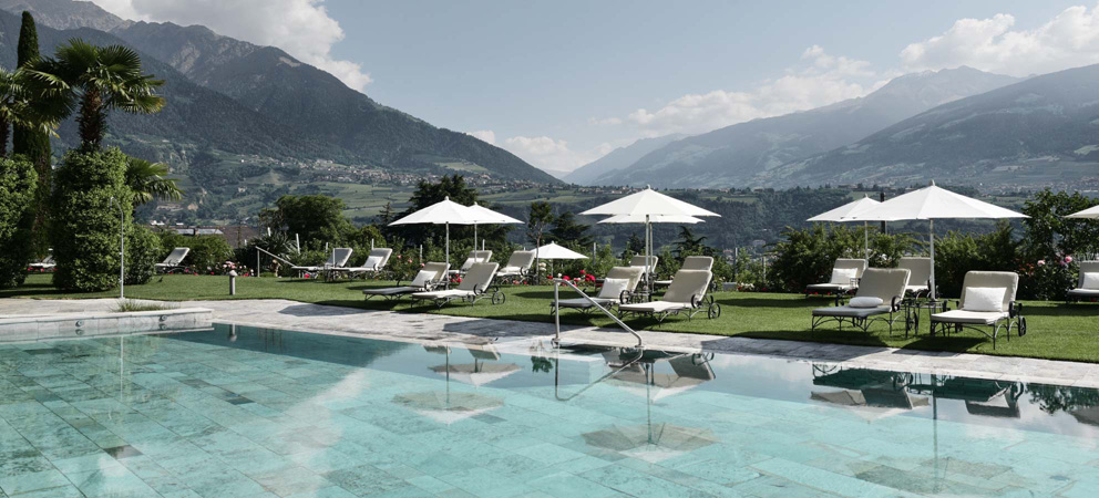 the Giardino Marling's outdoor pool, with sunbeds and parasols next to it