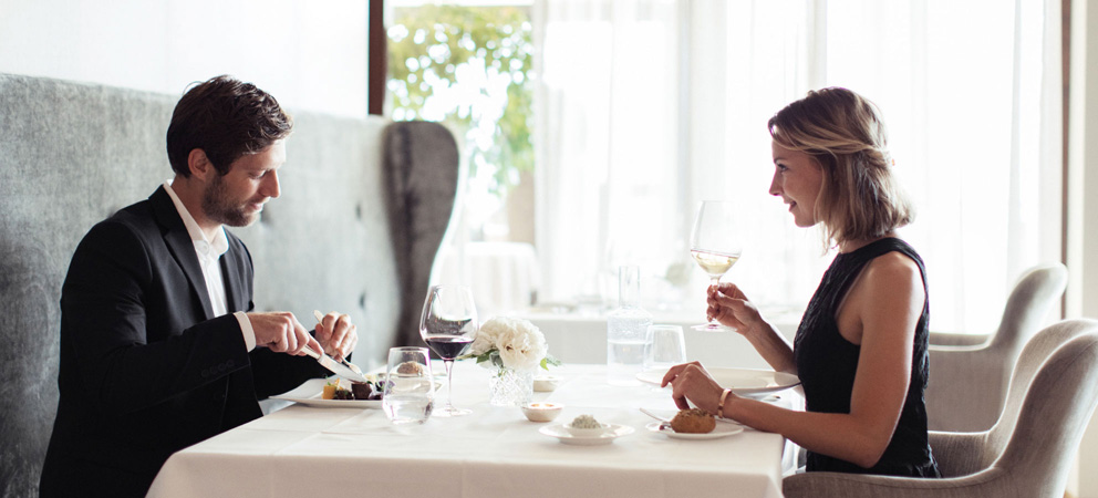Un couple élégant lors d'un déjeuner dans la salle à manger inondée de lumière de l'hôtel Giardino Marling