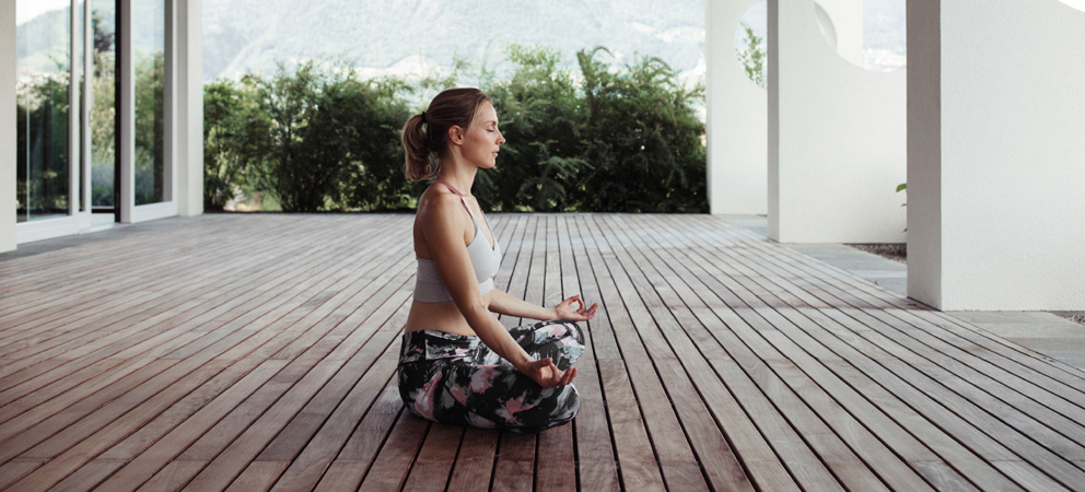 una giovane donna che medita a gambe incrociate all'Hotel Giardino Marling